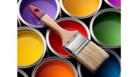 image of paint brush resting on paint cans