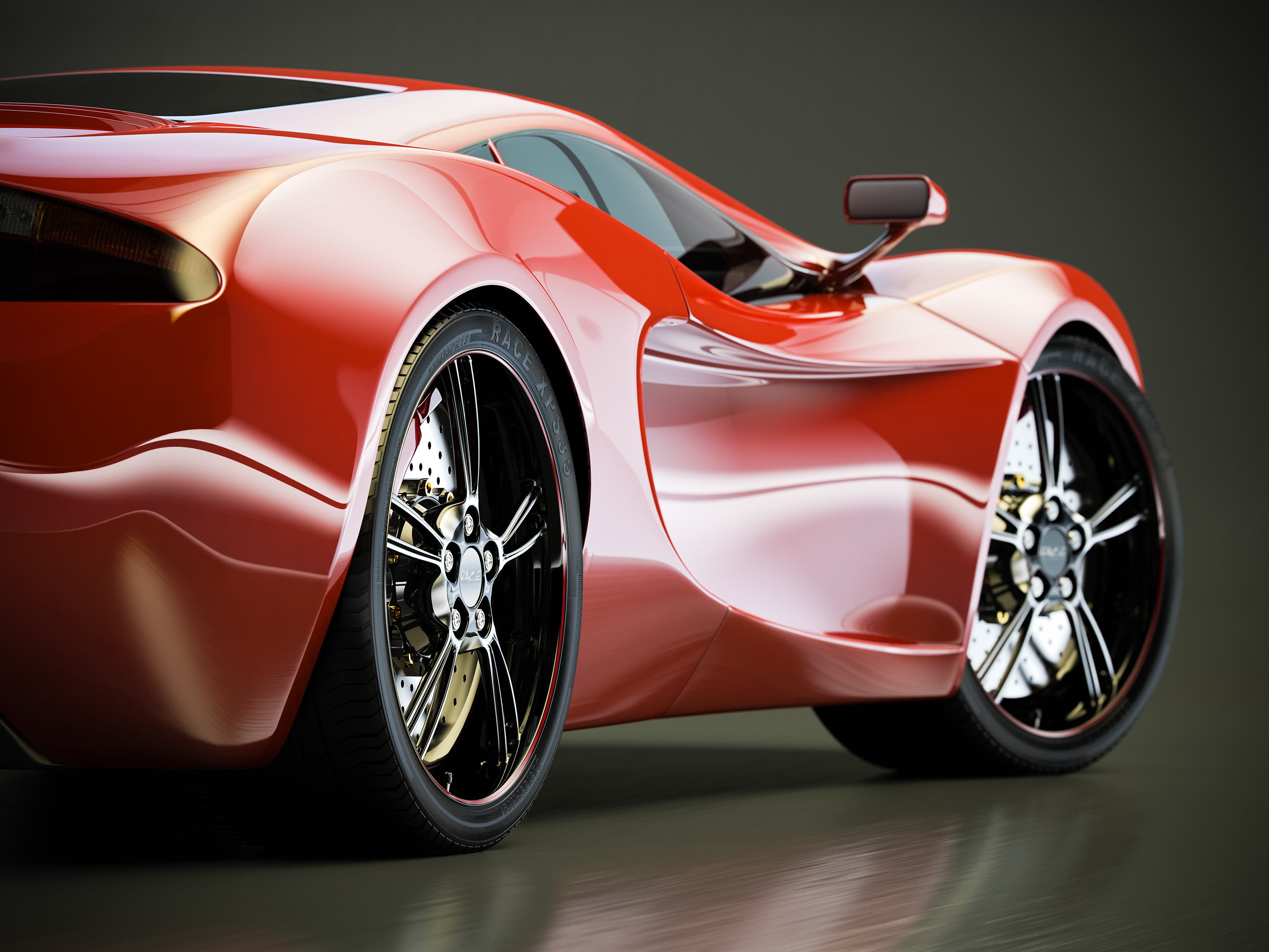 Close view of a sleek red sports car against a dark background