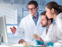 Group of scientists looking at desktop computer in the laboratory.