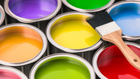 Open paint cans with colorful paint and brush